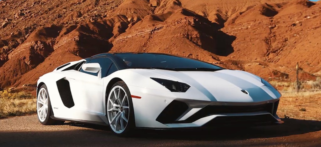 White Aventador parked against Moab red rock formations