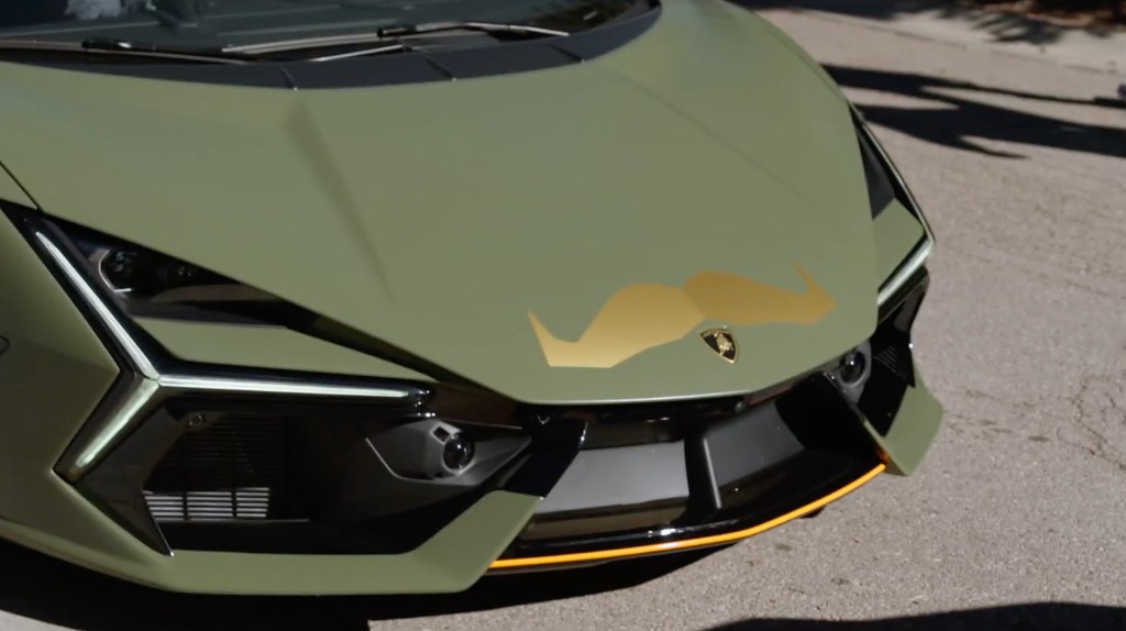Matte olive Lamborghini Revuelto with gold Movember mustache on the hood