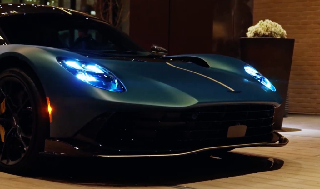 Aston Martin Valhalla headlights glowing on brick pavers at night